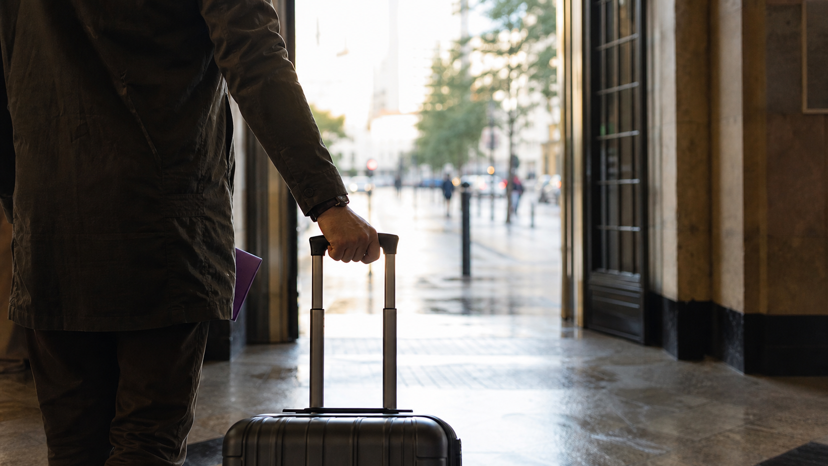 A traveller with luggage at a city threshold after arrival